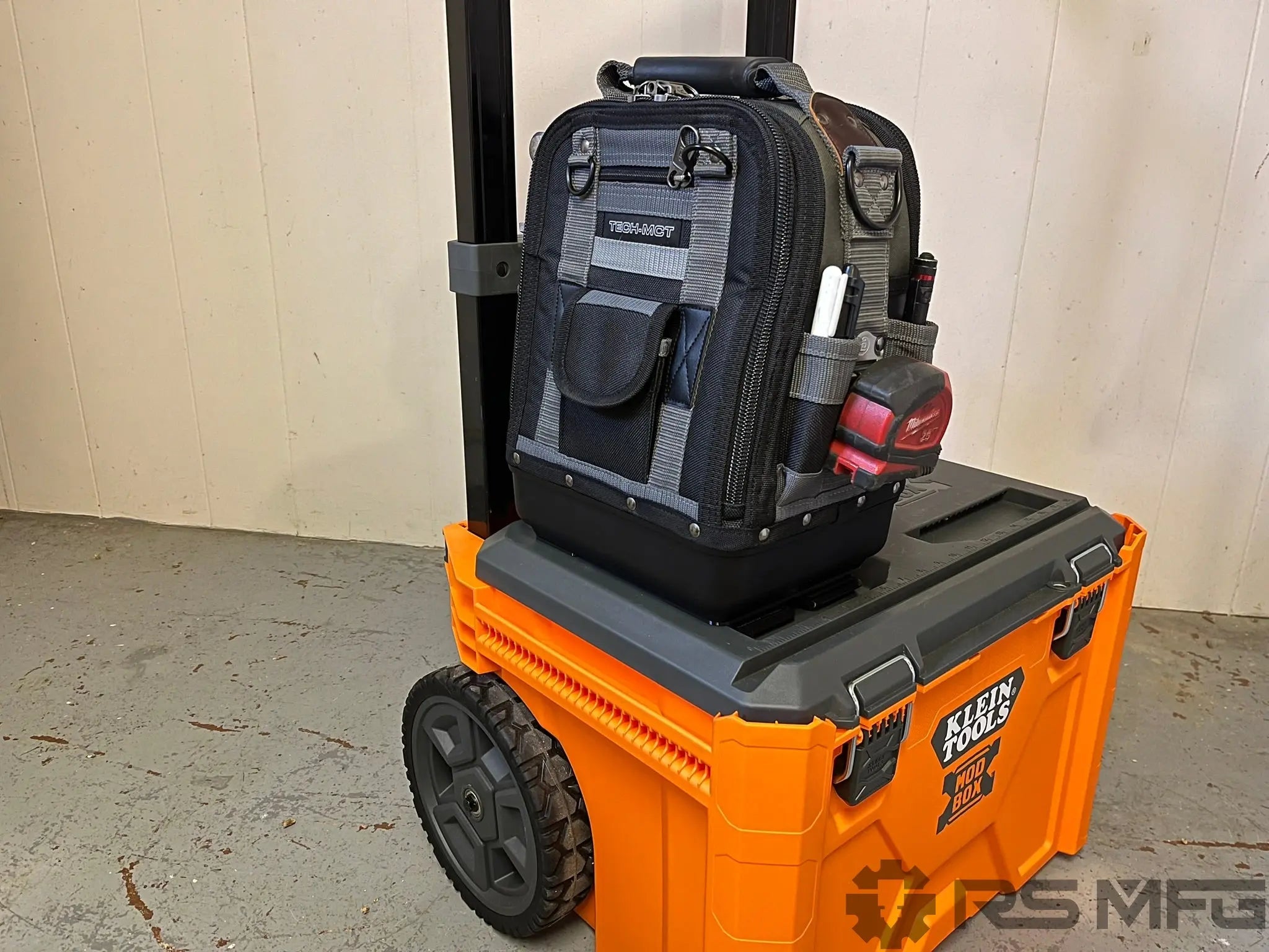 klein tools modbox with a veto pro pac tool bag on top, against a beige wall.